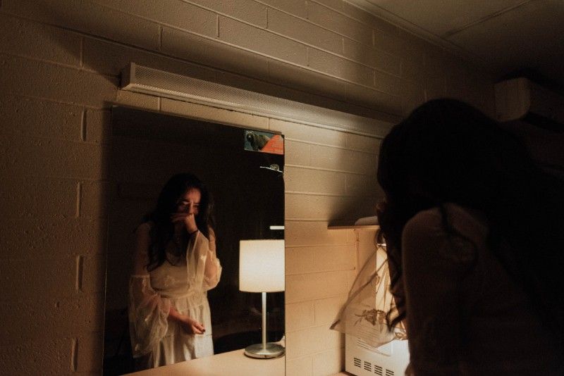 Frau weint vor dem Spiegel