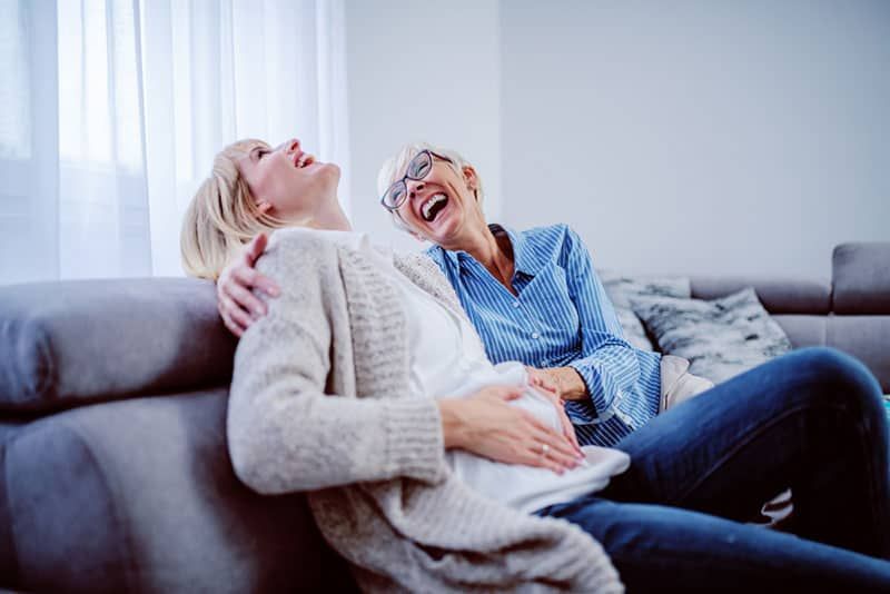 Tochter und Mutter lachen auf der Couch