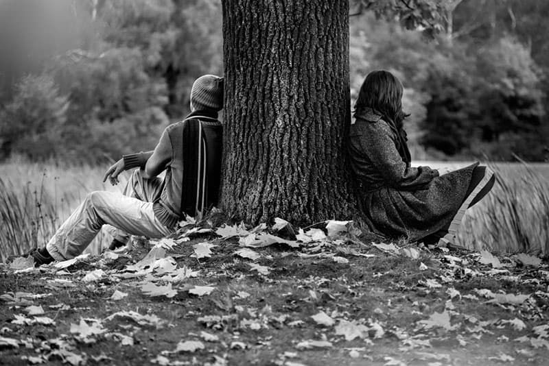 Mann und Frau sitzen nach Streit im Park