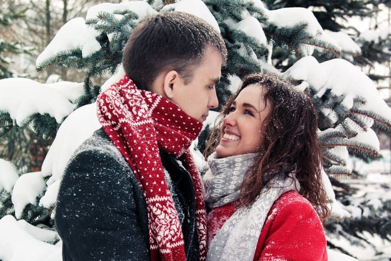 Süßes Paar im Schnee, das sich auf Augenhöhe anschaut