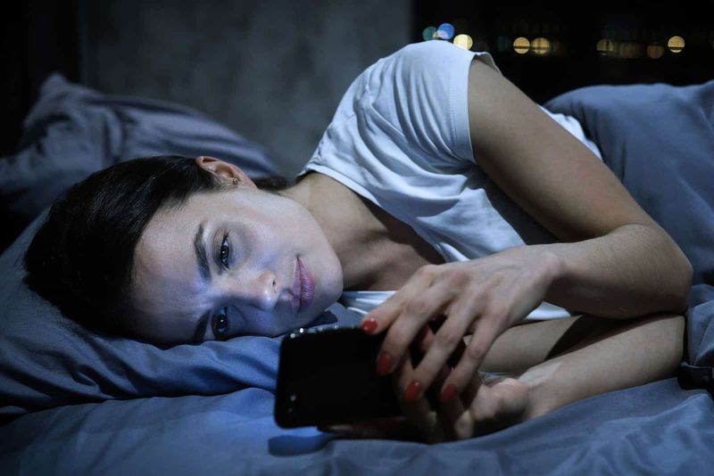 Mädchen liest ihre Nachrichten im Bett