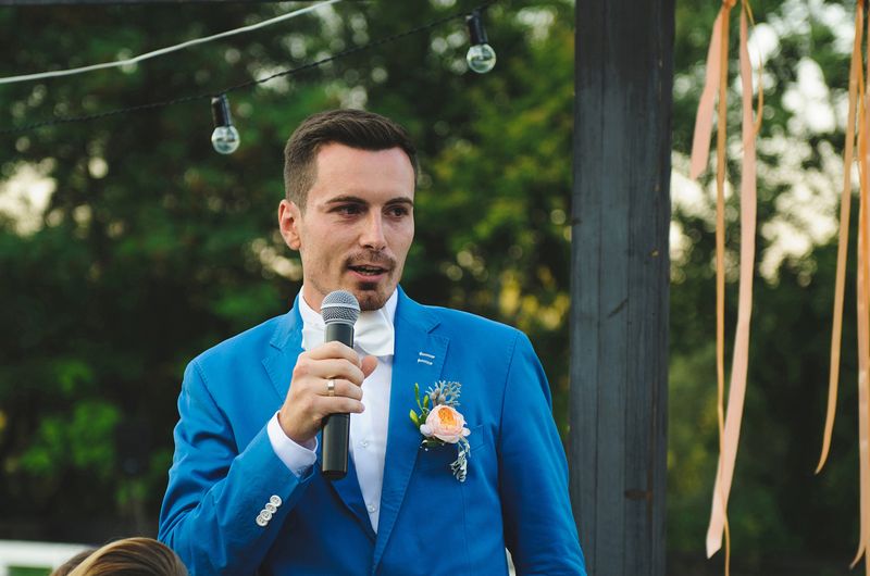 Ein Mann in einem blauen Anzug spricht auf einer Hochzeit