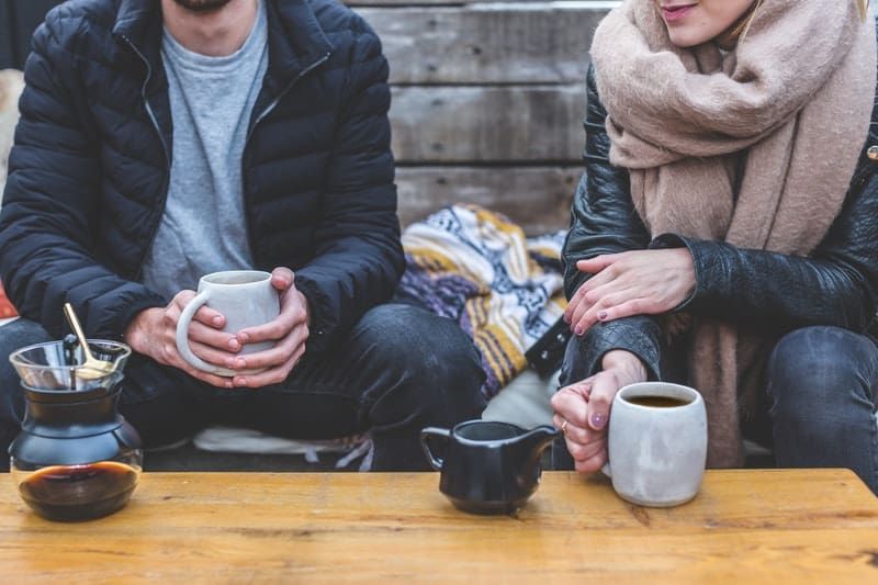Zwei Erwachsene unterhalten sich bei einer Tasse Kaffee