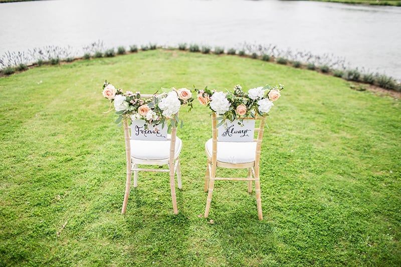 Zwei dekorative Stühle auf einer Wiese in der Nähe eines Gewässers