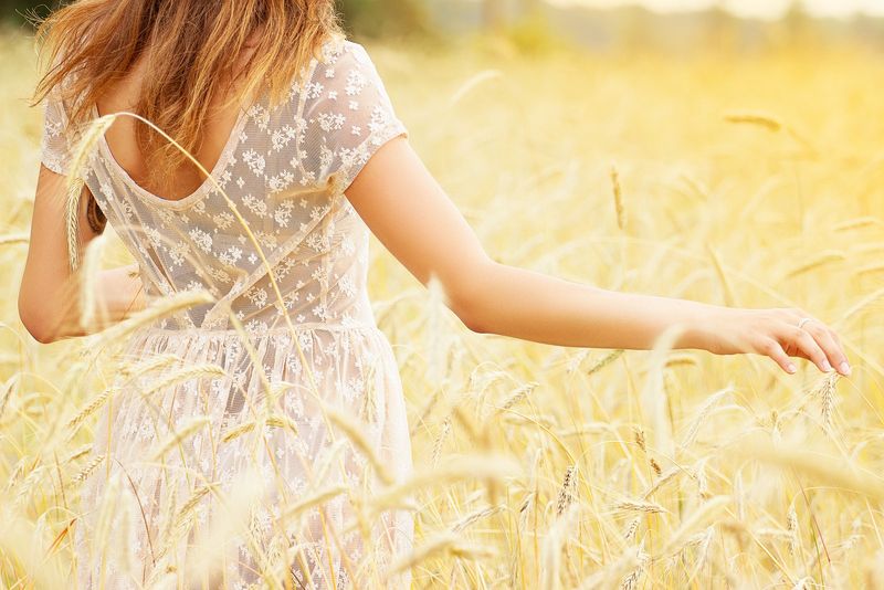 Mädchen mit weißem Kleid in einem Weizenfeld