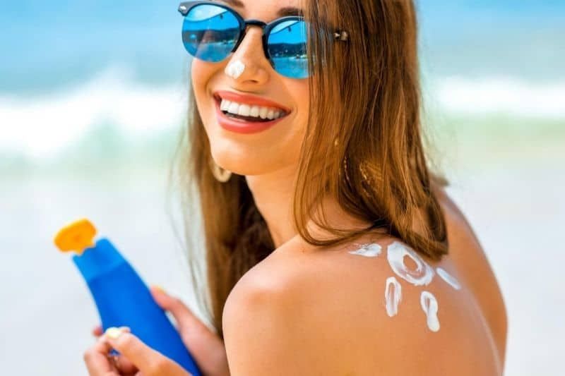 junge Frau mit einem Sonnenschutz, der mit einer Sonne auf der Schulter geformt ist
