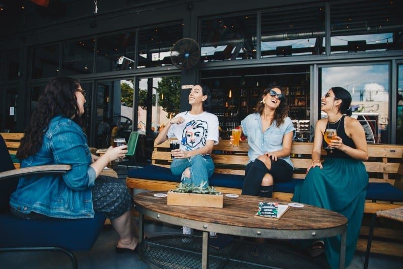Vier Frauen trinken Bier und unterhalten sich im Freien