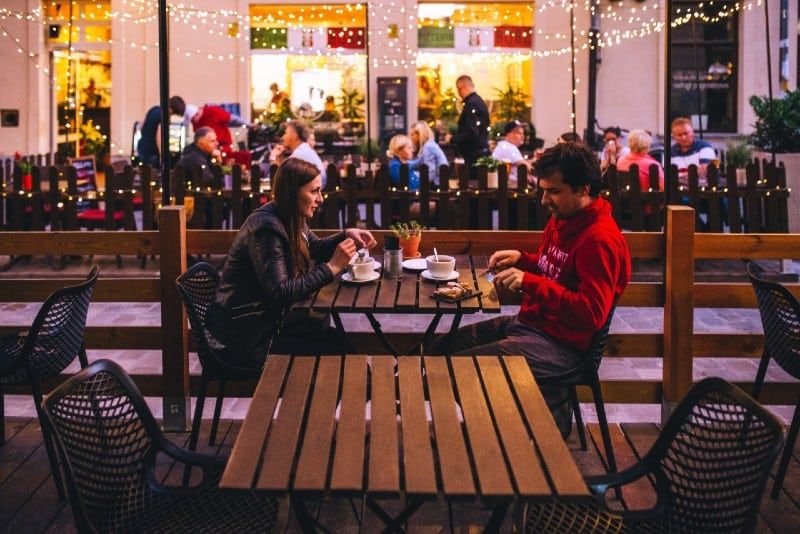 Mann und Frau trinken Kaffee und sitzen am Tisch im Freien
