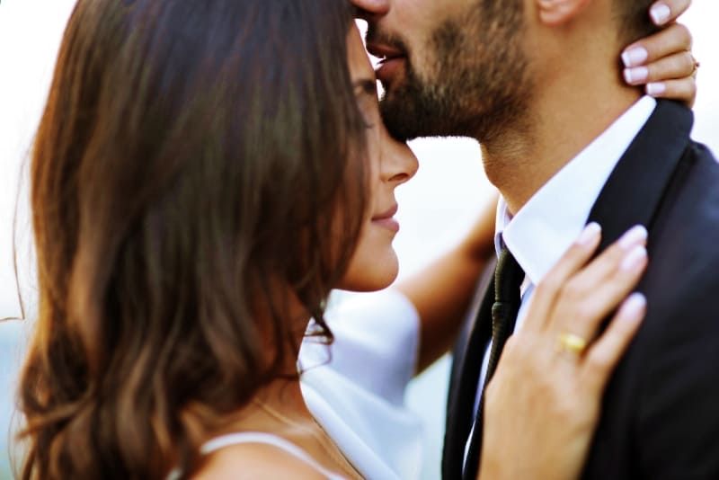 Mann im Anzug küsst Frau