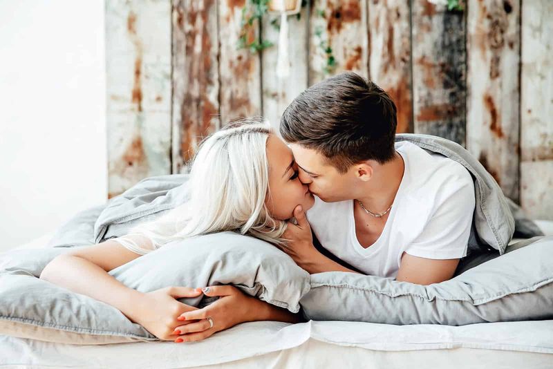 Junges Paar küsst sich im Bett