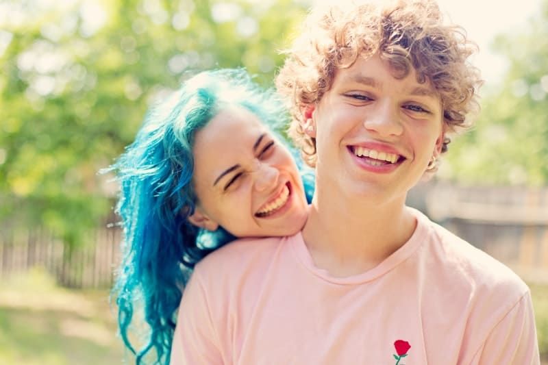 Frau mit blauen Haaren lächelt mit ihrem Freund