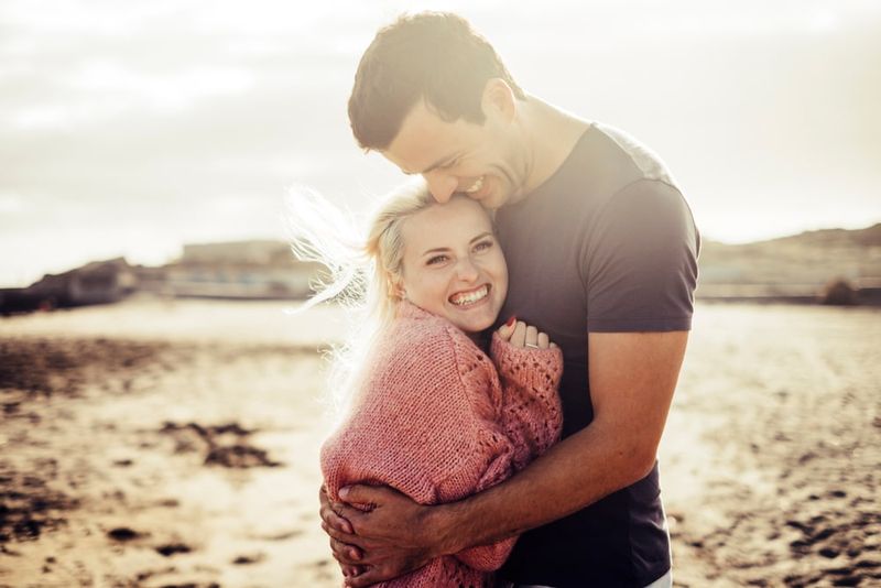 ein schönes junges Paar, das sich am Strand umarmt