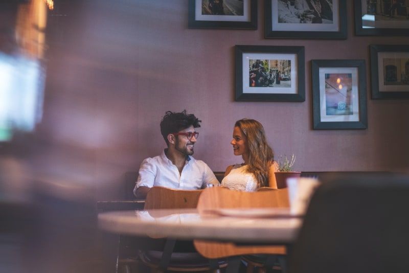 Lächelnder Mann und Frau, die im Café Augenkontakt herstellen