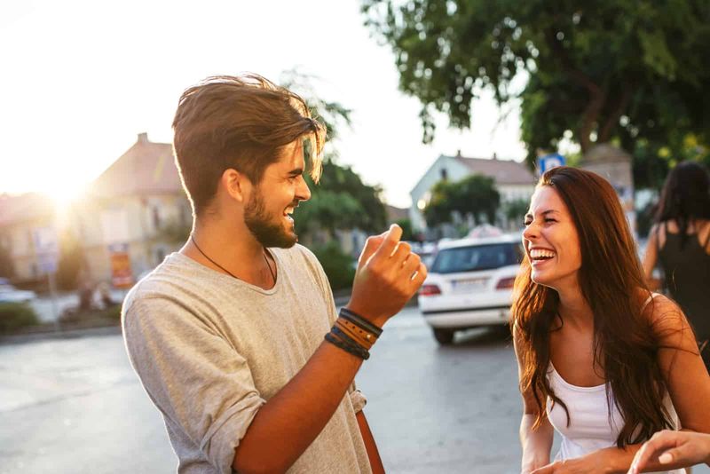 Ein Mann und eine Frau stehen lachend auf der Straße