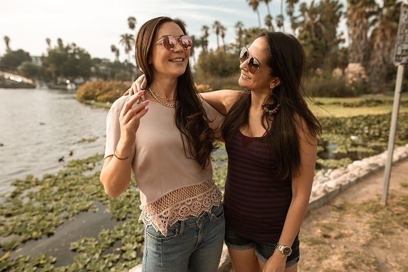 Zwei lächelnde Freundinnen unterhalten sich während des Spaziergangs