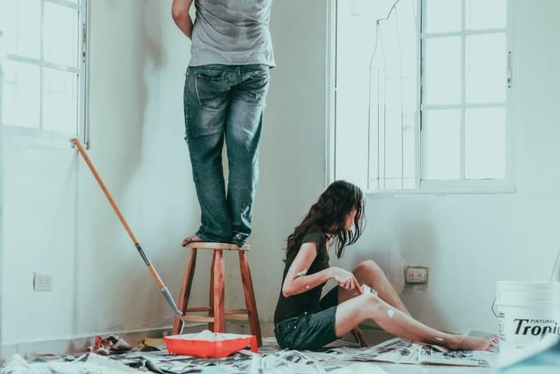 Mann und Frau malen Wand in ihrem Haus