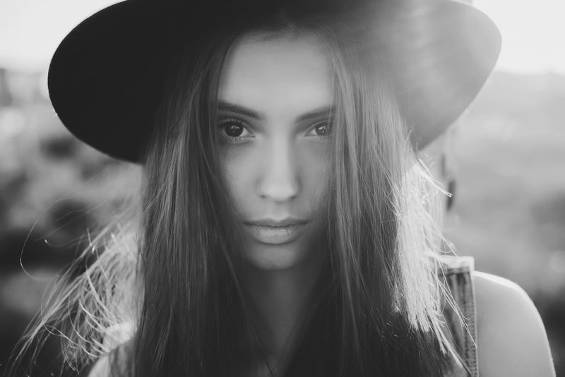 schönes junges Mädchen in einem schwarzen Hut