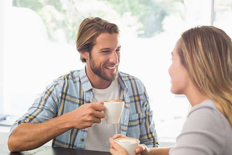 glückliches Paar spricht beim Kaffeetrinken
