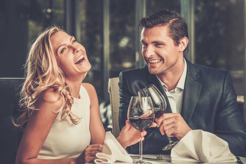 Der Mann und die Frau beim Abendessen lachen