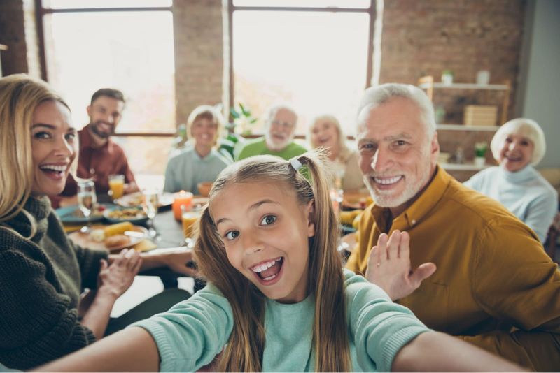 Eine große, glückliche Familie macht beim Mittagessen ein Selfie-Foto