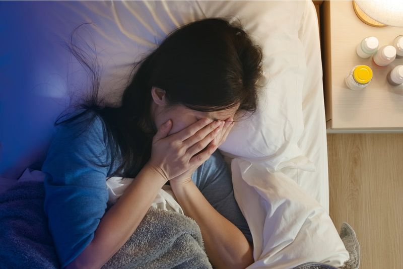 Eine deprimierte asiatische Frau liegt im Bett und weint