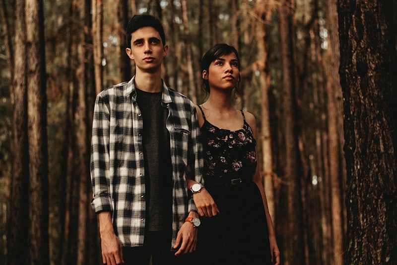 Mann und Frau stehen nebeneinander im Wald