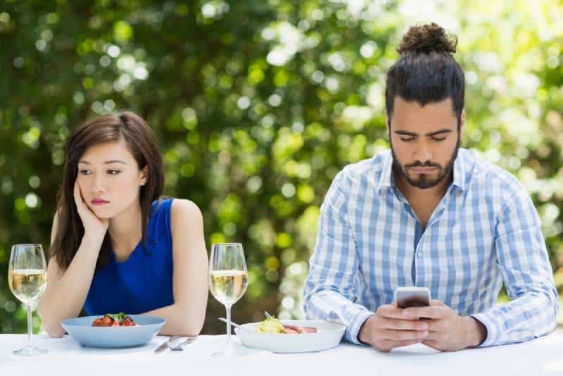 Mann ignoriert seine Freundin und benutzt Telefon