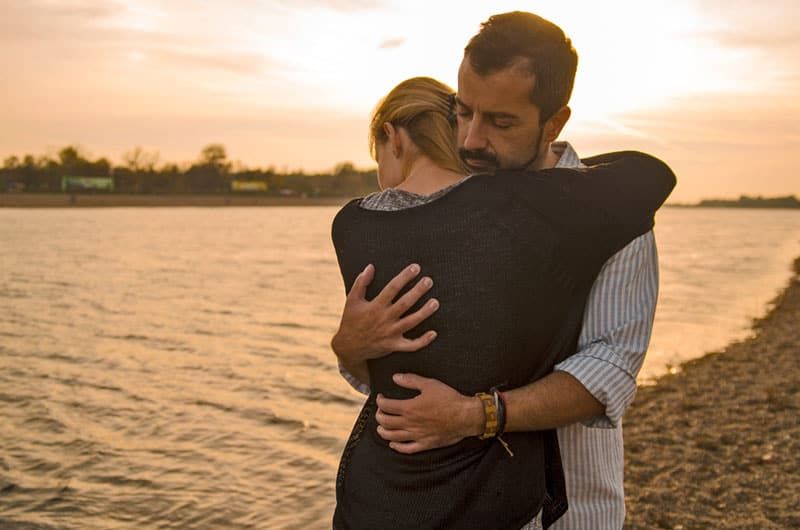 Paar umarmt sich draußen am See