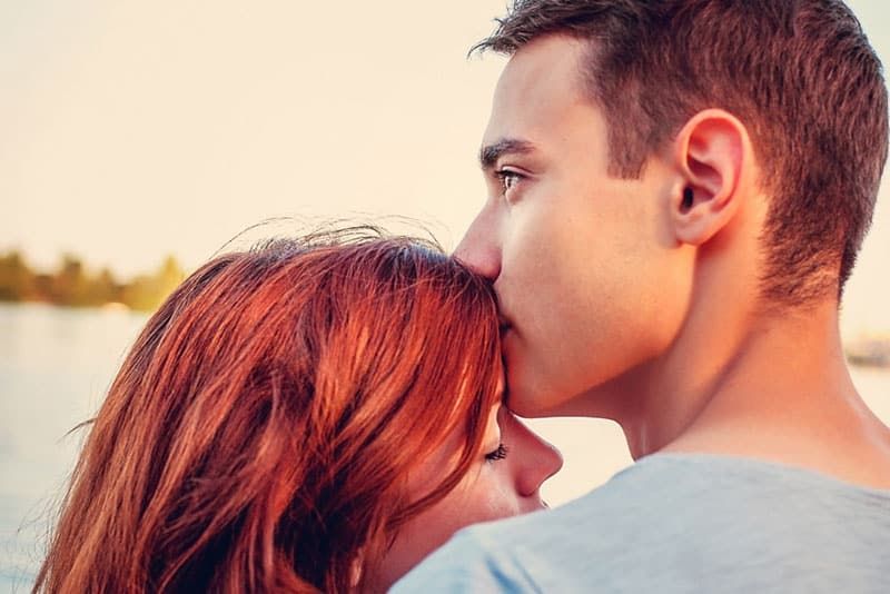Junge Frau küsst eine Frau auf die Stirn