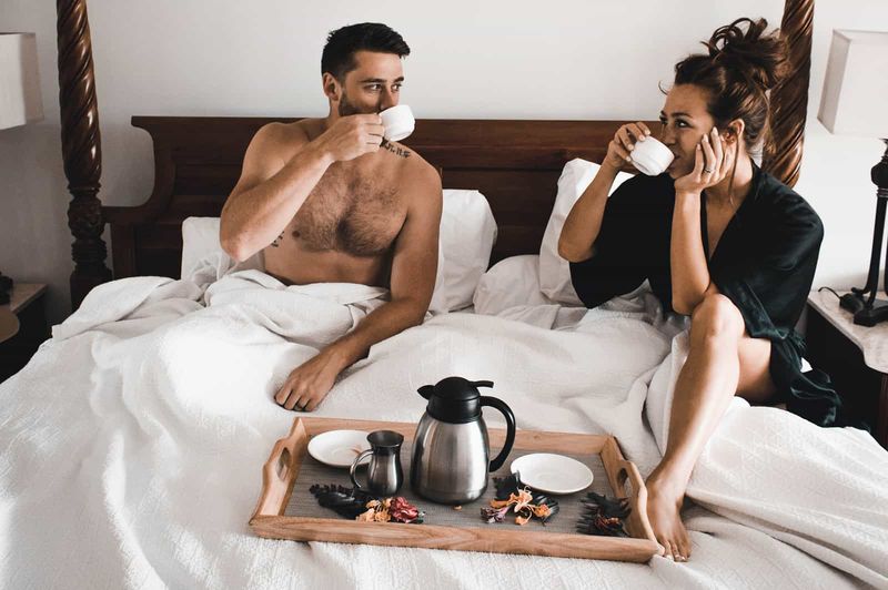 Liebespaar trinkt morgens Kaffee in einem Bett
