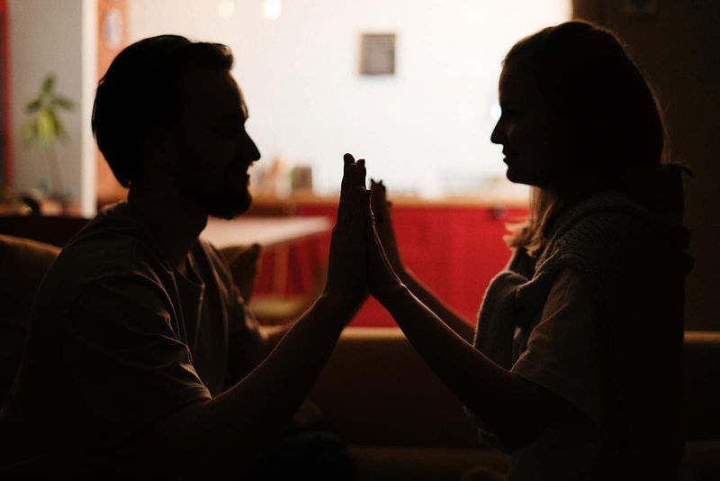 Romantisches Paar hält Händchen und schaut sich im Dunkeln an