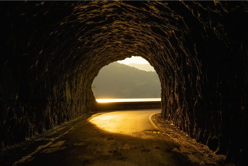 Wunderschöne Straße in einem felsigen Tunnel mit einem atemberaubenden Sonnenuntergang