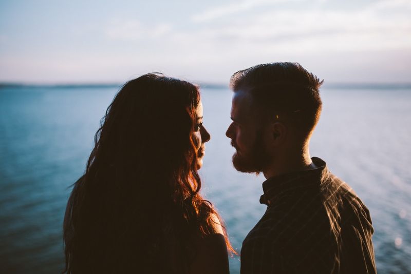 Mann und Frau nehmen Augenkontakt auf, während sie in der Nähe von Wasser stehen