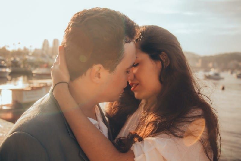 Mann und Frau küssen sich neben Bucht