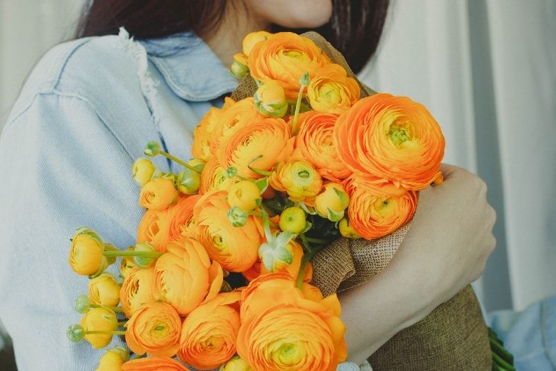 Frau mit gelben und orangefarbenen Blumen