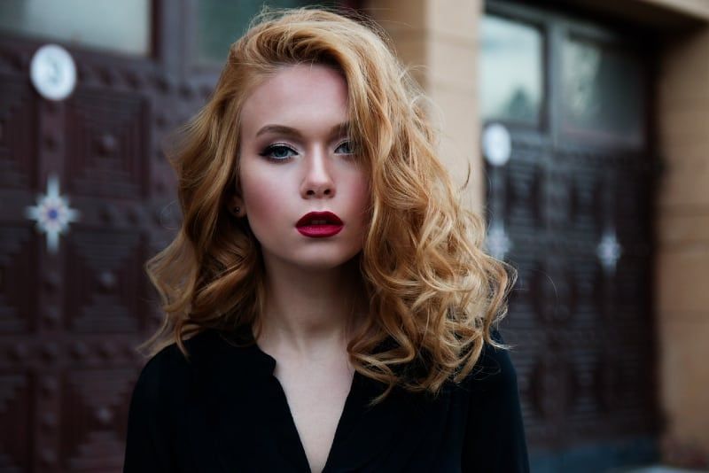 Porträt einer jungen blonden Frau mit rotem Lippenstift