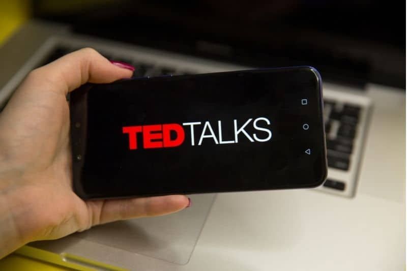 Ted-Talks-Logo auf dem Smartphone, das von einer beschnittenen Frau gehalten wird
