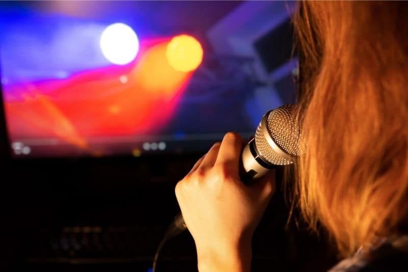 Frau, die während einer Selbstquarantäne allein Karaoke singt