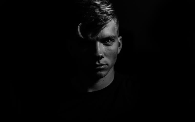 Schwarz-Weiß-Porträt eines Mannes in einem dunklen Raum