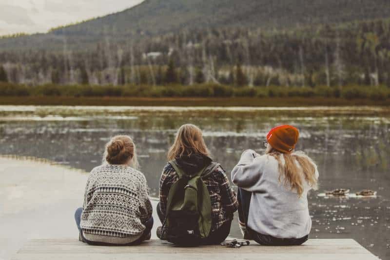 Drei Freundinnen sitzen am See