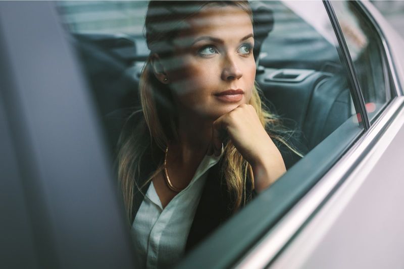 Geschäftsfrau sitzt auf dem Rücksitz eines Autos