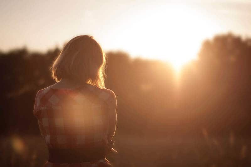 Rückansicht eines Mädchens, das während des Sonnenuntergangs steht