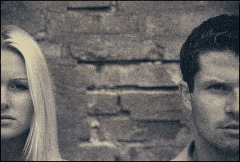 Foto von Mann und Frau in der Nähe der Backsteinmauer in grauem Schema