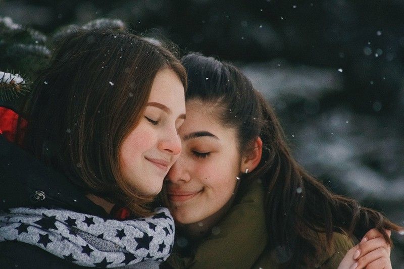 Zwei Frauen mit geschlossenen Augen umarmen sich
