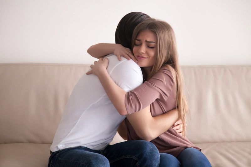 Traurige Frau umarmt Mann zu Hause