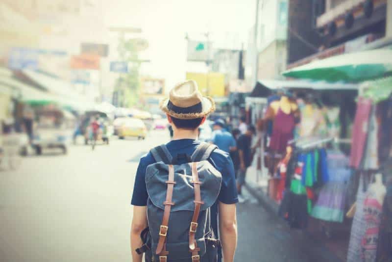 Tourist mit Hut läuft durch den Markt im Freien