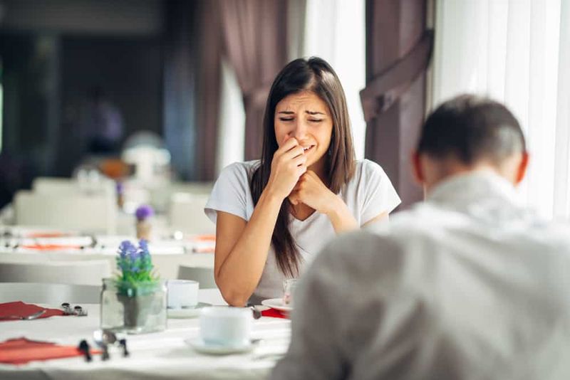 Weinende gestresste Frau mit ihrem Freund am Tisch