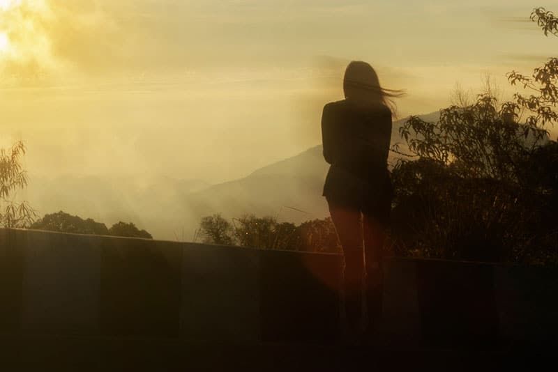 Silhouette einer Frau, die allein im Nebel steht