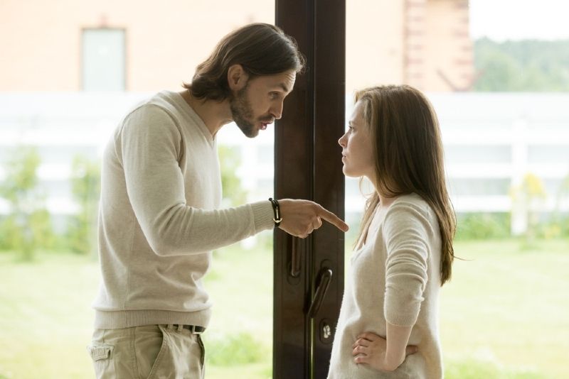 Mann spricht mit Frau, während er in der Nähe der Tür steht