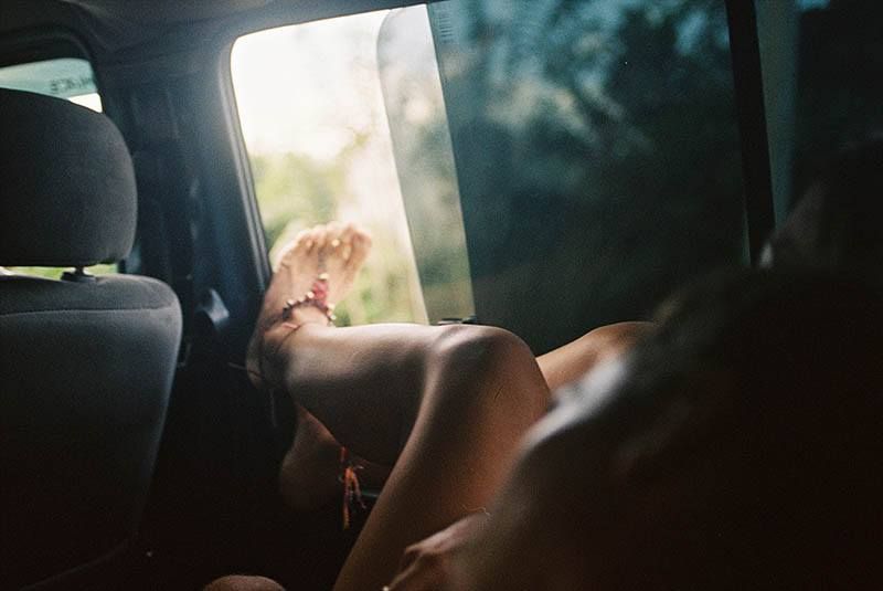 Mädchen legt während der Fahrt Beine auf Autofenster